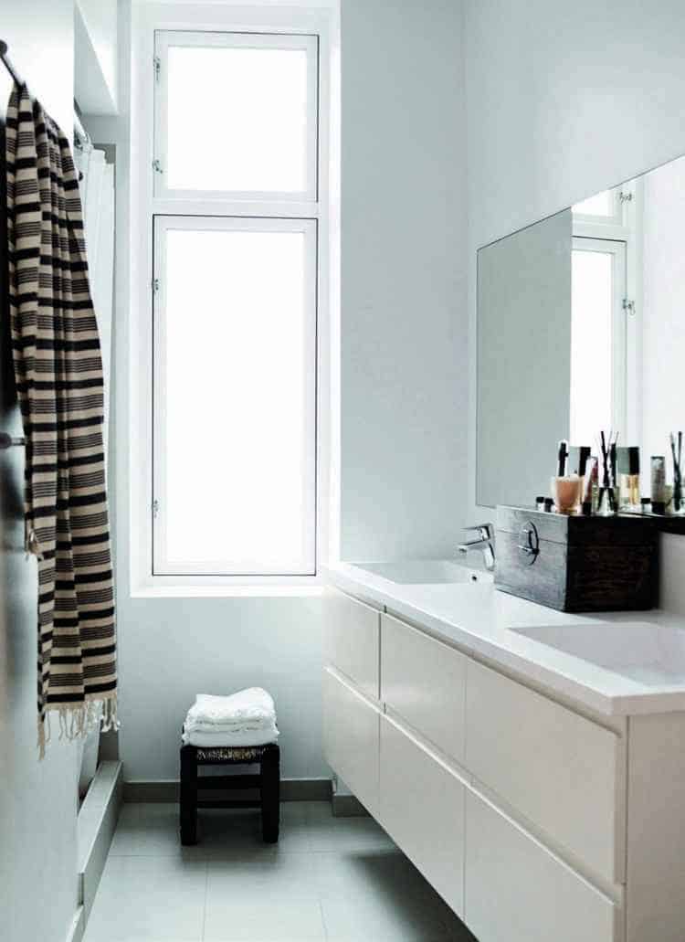 Small Scandinavian bathroom with large window and cupboards without handle